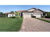 Charming home showcasing a brick driveway, a two-car garage, manicured lawn, and a stone-accented facade at 4189 Marseille Ln, Lakeland, FL 33810