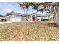 Charming single-story home with well-maintained landscaping and a bright red front door at 423 Lark Ct, Kissimmee, FL 34759