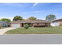 Charming single-story brick home featuring an attached two-car garage and well-manicured front lawn at 5432 Weber Pl, Lakeland, FL 33809