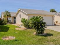 Charming home with manicured lawn, mature palm trees and attached two-car garage at 3960 W Cypress Lndg, Winter Haven, FL 33884