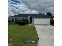 Charming single-story home with a well-maintained lawn, blue door, and a two-car garage at 120 Flatfish Ct, Kissimmee, FL 34759