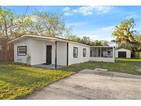 Charming single-story home featuring a white exterior, covered porch, and well-maintained landscaping at 126 Mason St, Auburndale, FL 33823