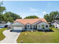 Charming single-story home boasts a well-manicured lawn, red roof, and attached two-car garage at 1931 Matthew Ct, Lakeland, FL 33813