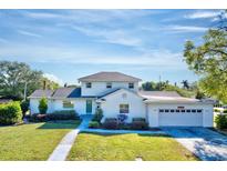 Charming two-story home with a well-maintained lawn, beautiful landscaping, and attached two-car garage at 2816 Fairmount Ave, Lakeland, FL 33803