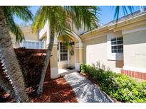 Charming front entrance with a decorative wreath on the door and lush tropical landscaping at 3071 Shoal Creek Village Dr, Lakeland, FL 33803