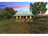 Charming single-story home featuring a green metal roof and spacious front yard with mature trees, offering classic curb appeal at 3530 Hamilton Rd, Lakeland, FL 33811