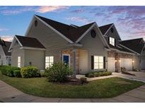Charming townhome featuring stone accents, a well-manicured lawn, and a welcoming blue front door at 4227 Hartridge Ln, Lakeland, FL 33813