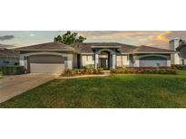 Charming single-story home featuring manicured landscaping, a two-car garage, and classic architectural details at 5638 Bloomfield Blvd, Lakeland, FL 33810