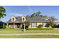 Charming two-story home featuring dormer windows, manicured lawn, and lush landscaping at 5789 Lake Victoria Dr, Lakeland, FL 33813