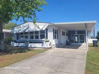 Charming single-story home with awnings, carport, and well-maintained lawn on a bright day at 3038 Galaxy Ln, Lakeland, FL 33801