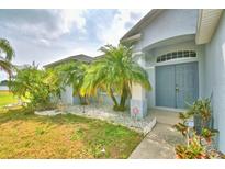 Charming blue home featuring a double door front entrance, palm trees, and rock landscaping at 4069 Byrds Crossing Dr, Lakeland, FL 33812