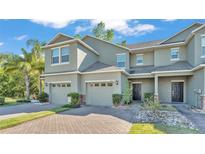 Stylish two-story townhome featuring a brick driveway, attached garages, and beautiful landscaping at 6347 Torrington Cir, Lakeland, FL 33811