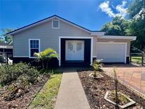 Charming single-story home featuring a garage, quaint landscaping, and a welcoming walkway at 932 Augusta St, Lakeland, FL 33805