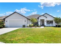 Charming single-story home featuring a manicured lawn and a welcoming front porch at 140 Heritage Park Ln, Mulberry, FL 33860