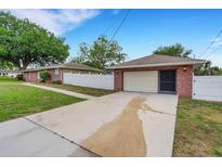 Spacious driveway leads to a detached two-car garage, complemented by mature trees at 202 Saint Lucie Rd, Winter Haven, FL 33884