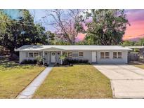 Charming single-story home with a well-manicured lawn, mature trees, and a welcoming walkway at 2410 Nw Avenue B, Winter Haven, FL 33880