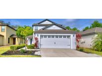Charming two-story home featuring a large garage with classic design elements and manicured landscaping at 6286 Manitoba Dr, Lakeland, FL 33805