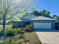 Charming single-story home with a well-maintained lawn, a large garage, and beautiful landscaping at 811 W Heron Pl, Winter Haven, FL 33884