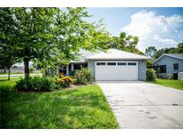 Charming single-story home with a well-manicured lawn and a two car garage in a quiet neighborhood at 811 W Heron Pl, Winter Haven, FL 33884