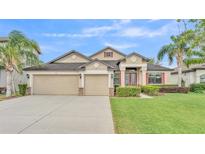 Attractive exterior with a well-manicured lawn, three-car garage, and lush landscaping at 1342 Heritage Landings Dr, Lakeland, FL 33805
