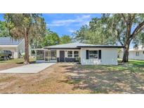 Charming single-story home with white facade, dark trim, and a welcoming screened-in porch at 1650 W Mcleod St, Bartow, FL 33830