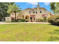 Charming multi-story home features a stucco exterior, red tile roof, arched entry, and a lush green lawn at 845 E Edgewood Dr, Lakeland, FL 33803