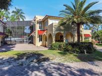 A Mediterranean-style home with stucco walls, red tile roof, arched entryway, and a sunroom with an enclosed pool at 845 E Edgewood Dr, Lakeland, FL 33803
