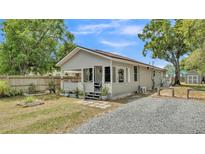 Charming single-story home featuring a cozy front porch, gray siding and gravel driveway at 1105 Terry S Ave, Lakeland, FL 33815