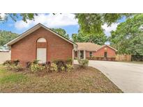 Charming single-story brick home with a well-maintained lawn and a curved driveway at 1205 Scottsland Dr, Lakeland, FL 33813