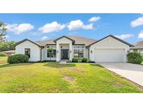 Beautiful single-story home featuring a well-manicured lawn and a two-car garage at 185 Heritage Park Ln, Mulberry, FL 33860
