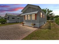 Charming manufactured home with brick paved drive, flowers and sunset view at 2511 Limewood Ave, Clermont, FL 34714