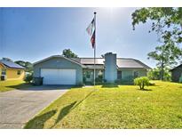 Beautiful single-Gathering home with lush green lawn, solar panels, and an American flag waving high at 2836 Magnolia Ave, Lakeland, FL 33812