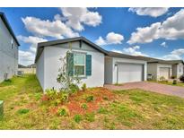 Charming single-story home featuring a one-car garage, well-maintained lawn, and beautiful landscaping at 3208 Weitzel Dr, Haines City, FL 33844