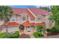 Beautifully landscaped condo featuring a red tile roof and neutral color palette at 405 Enclave Pl # 405, Lakeland, FL 33803