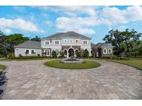 Stately two-story home with fountain, circular driveway, and beautifully landscaped front yard at 460 Canterwood Dr, Mulberry, FL 33860