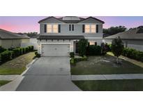 Charming two-story home with gray siding, well-manicured lawn, and a convenient two-car garage at 4886 St James Ln, Winter Haven, FL 33881