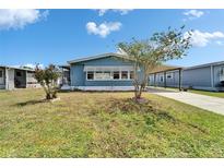 Cozy single-story home featuring a carport and landscaped front yard under a bright blue sky at 5015 Fox Cliff Dr, Lakeland, FL 33810
