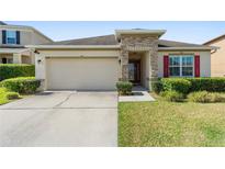 Charming single-story home featuring a two car garage, stone accents, and a well-manicured front yard at 5793 Dornich Dr, Auburndale, FL 33823
