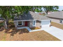 Aerial view of a single-story home with a freshly paved driveway, manicured front yard, and new landscaping at 6625 Thornhill Rd, Winter Haven, FL 33880