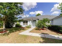 Charming single-story home with mature landscaping, lush lawn, and inviting walkway to front door at 6626 Royal Forest Dr, Lakeland, FL 33811