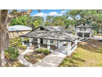 Charming home features a classic design with a welcoming front porch and a detached garage at 828 E Valencia St, Lakeland, FL 33805