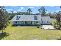 Charming single-story home featuring a well-manicured front lawn and classic dormer windows at 8337 Fussell Rd, Polk City, FL 33868