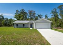 A well-manicured front lawn leads to a charming home with a two-car garage at 14385 Sw 39Th Court Rd, Ocala, FL 34473