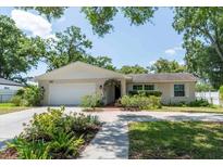 Charming single-story home with well-manicured lawn, arched entryway and white garage door at 1503 Clairdale Ln, Lakeland, FL 33801