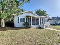 Charming one-story home featuring a screened-in porch, blue shutters and a well-maintained front lawn at 319 E Johnson Ave, Lake Wales, FL 33853