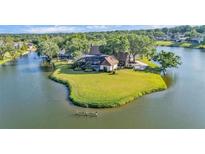 Aerial view of lakefront house situated on a peninsula with lush greenery and stunning water views at 3906 Canyon Lake Pt, Lakeland, FL 33813