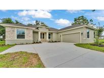 Charming single-story home with stone accents, a well-manicured lawn, and a spacious driveway leading to a two-car garage at 505 Shanklin Ave, Bartow, FL 33830