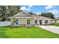 Beautiful single-story home featuring a well-manicured lawn, stone accents, and a stylish, modern design at 803 Allison Place, Bartow, FL 33830