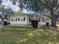 Charming single-story home with white siding, black shutters, and a well-maintained lawn at 1610 Reynolds Rd # 80, Lakeland, FL 33801