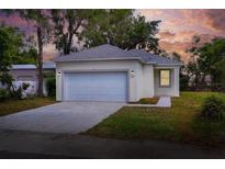 Charming single-story home featuring a two-car garage, neutral paint, and landscaped front yard under a colorful evening sky at 1850 Martin Luther King, Jr. E Blvd, Bartow, FL 33830